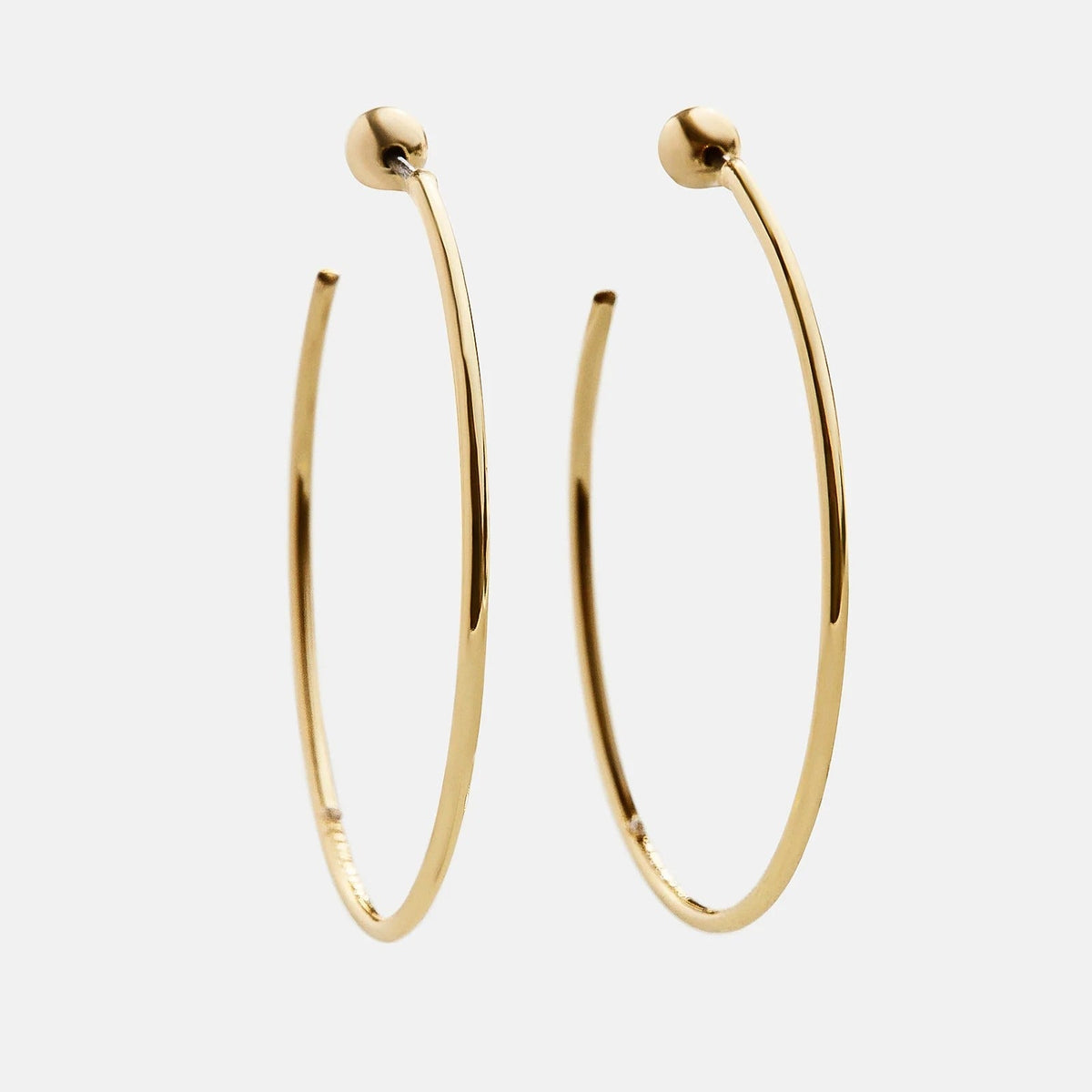 Lavisa Dalilah thin gold hoop earrings displayed on a neutral background