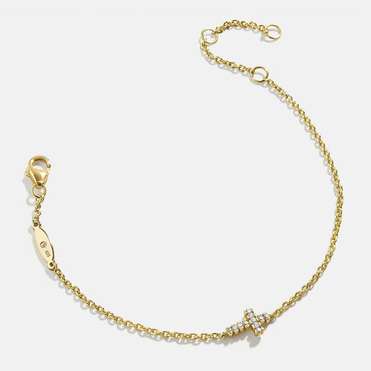 Lavisa 18K gold cross charm bracelet with cubic zirconia stones on display