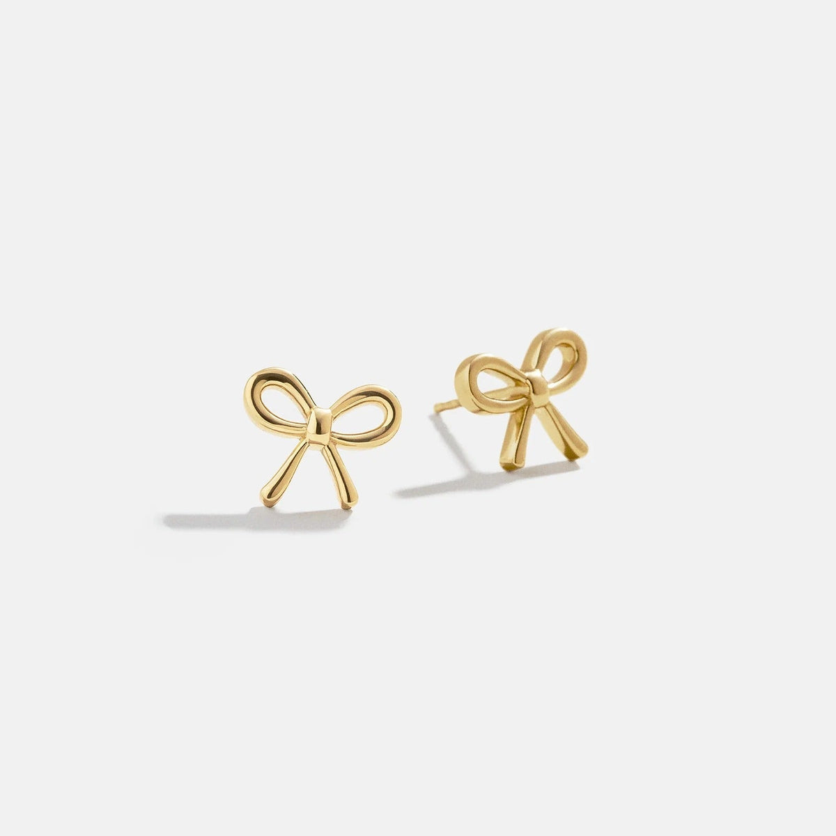 Lavisa delicate gold bow stud earrings featuring a polished finish