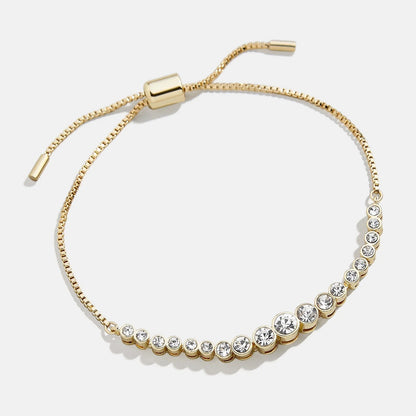 Lavisa Pavé Crystal Pull Tie Tennis Bracelet in gold with sparkling bezel-set stones.
