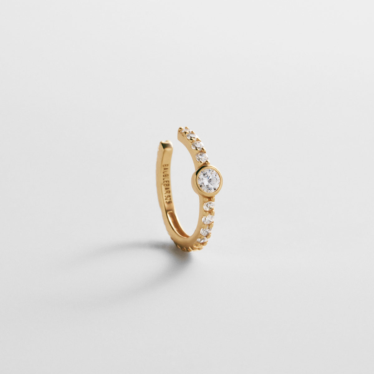 Lavisa 18K Gold Pave Ear Cuff resting on a clean surface showcasing sparkling stones