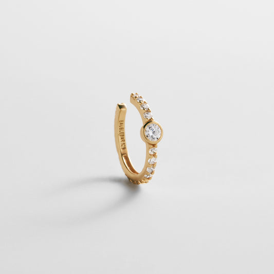 Lavisa 18K Gold Pave Ear Cuff resting on a clean surface showcasing sparkling stones