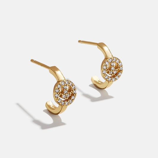 Lavisa pavé smiley face gold stud earrings sparkling under studio lights