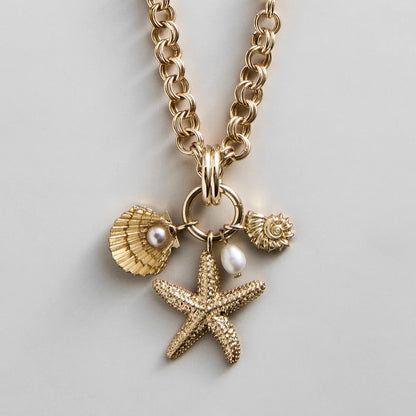 Lavisa gold and pearl charm necklace featuring seashell and starfish charms
