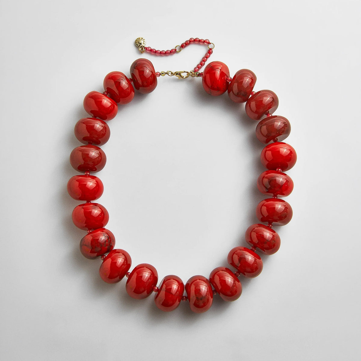Lavisa red jasper and resin beaded statement necklace on a white surface