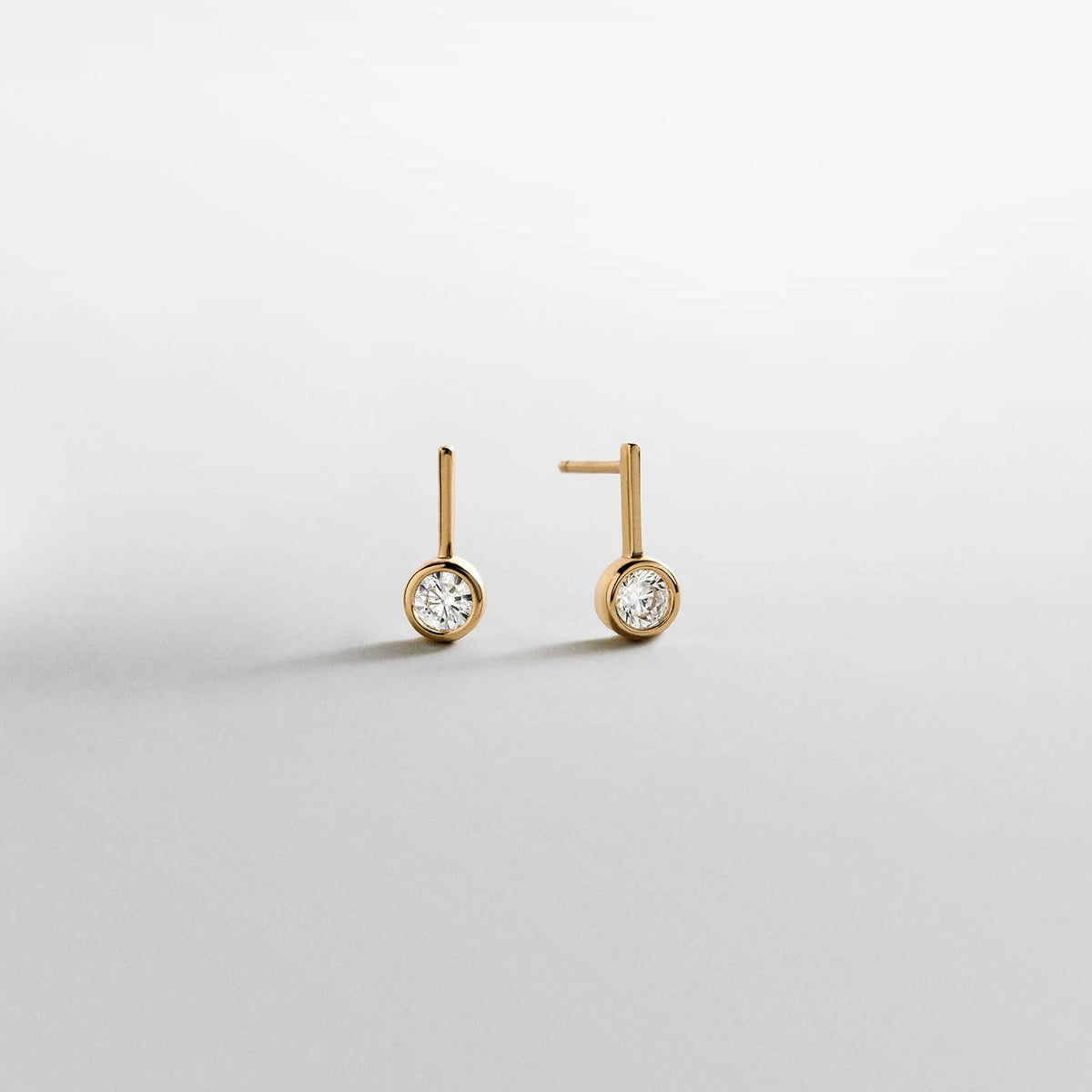 Lavisa Fallon 14K gold bezel huggie earrings with round crystal stone