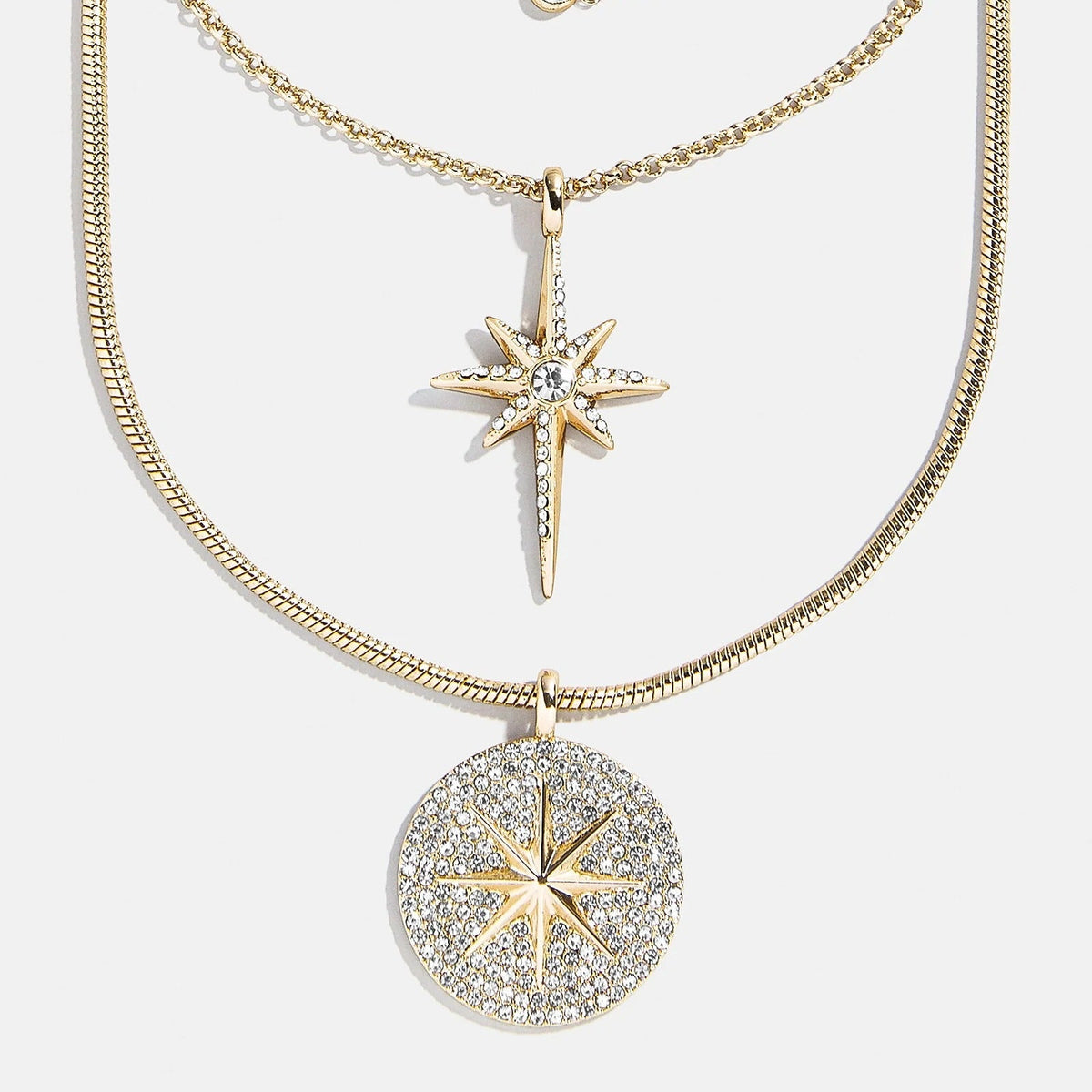 Lavisa Lyra celestial layered necklace featuring gold chains and star pendants.