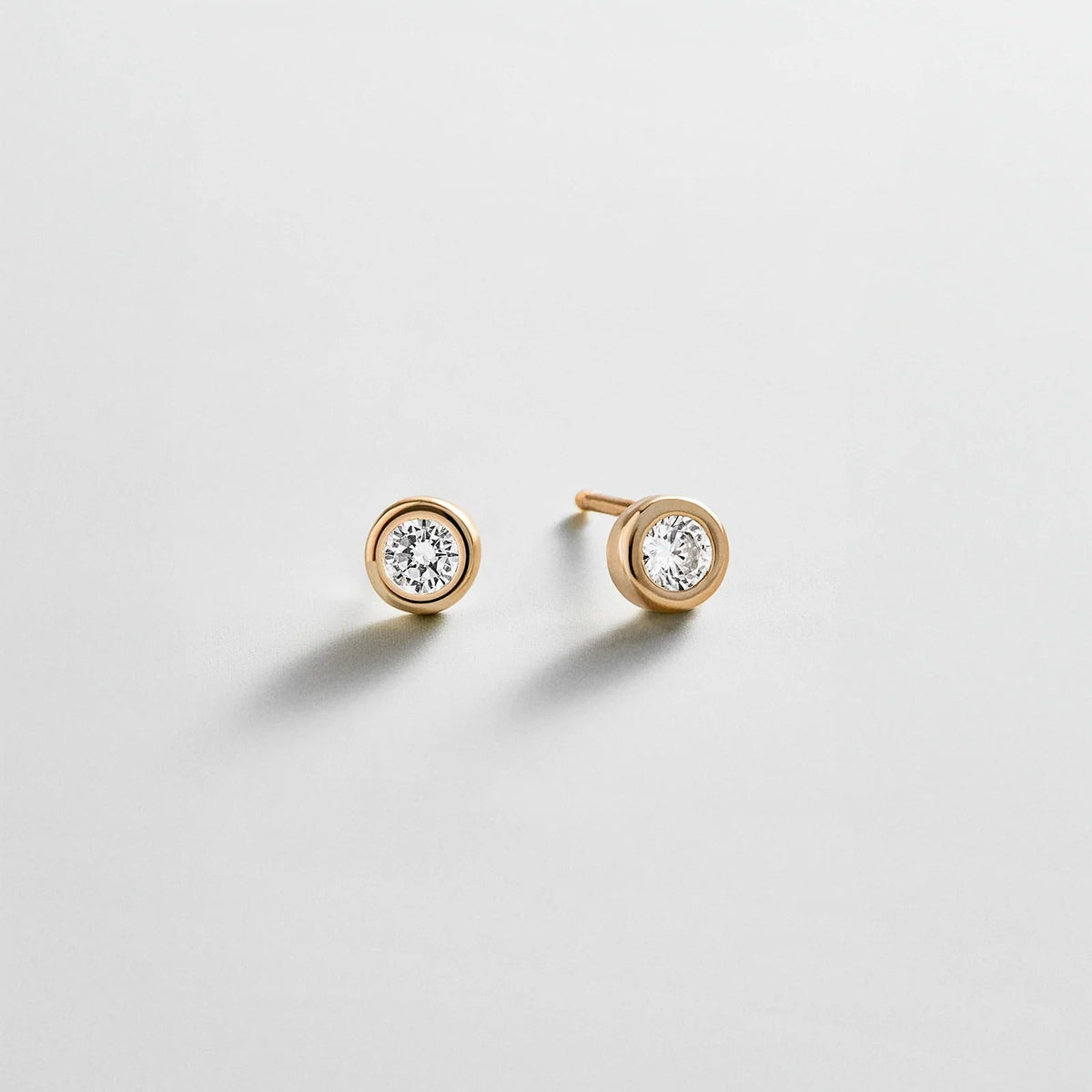 Lavisa gold stud earrings featuring a round crystal stone in a sleek bezel setting