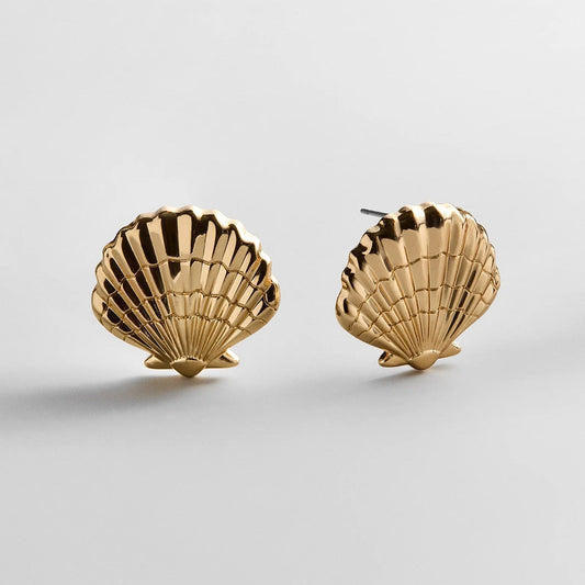 Lavisa gold seashell dangle earrings with detailed etching on a neutral background