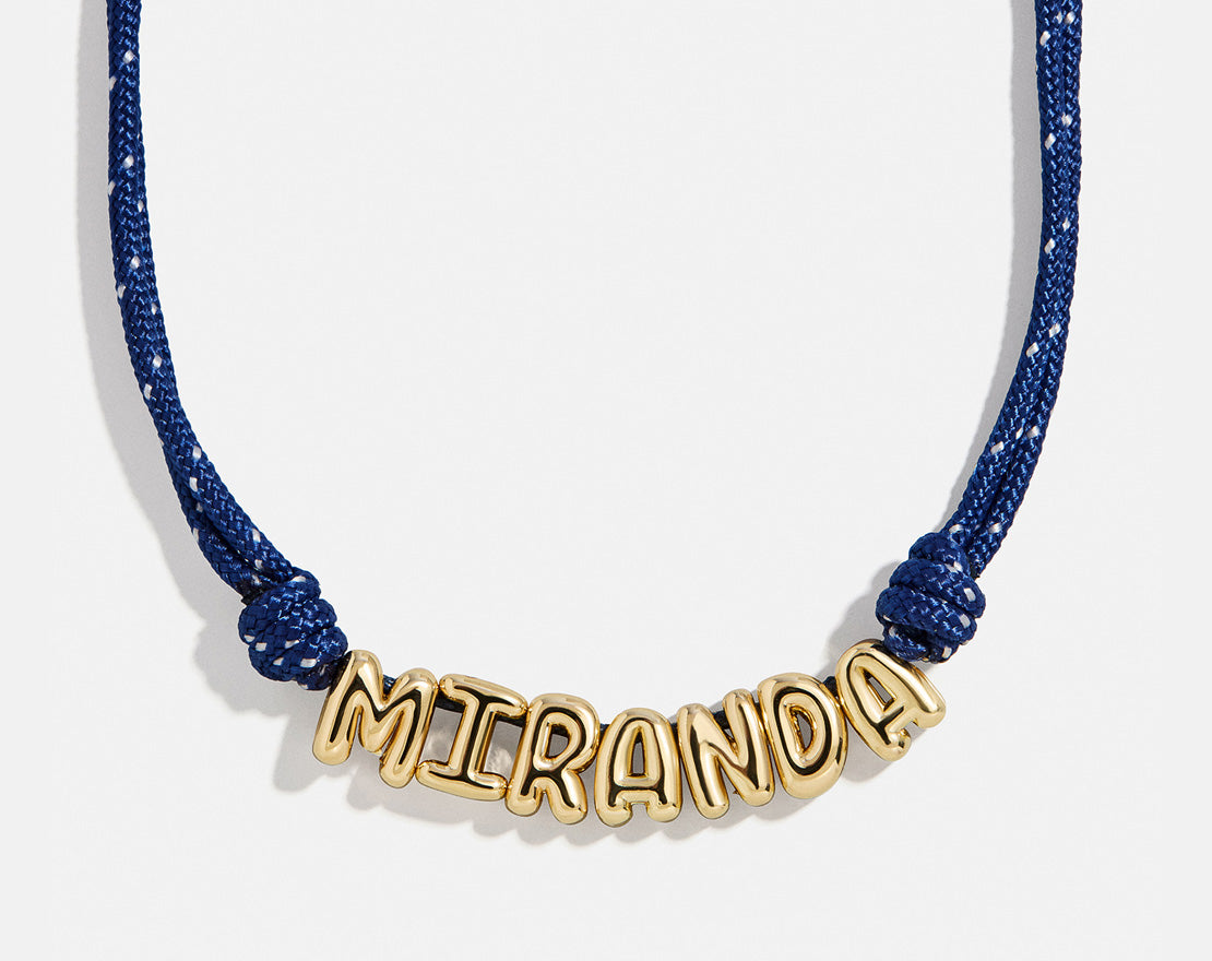 Lavisa custom bubble letter necklace with gold letters on a navy paracord