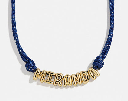 Lavisa custom bubble letter necklace with gold letters on a navy paracord