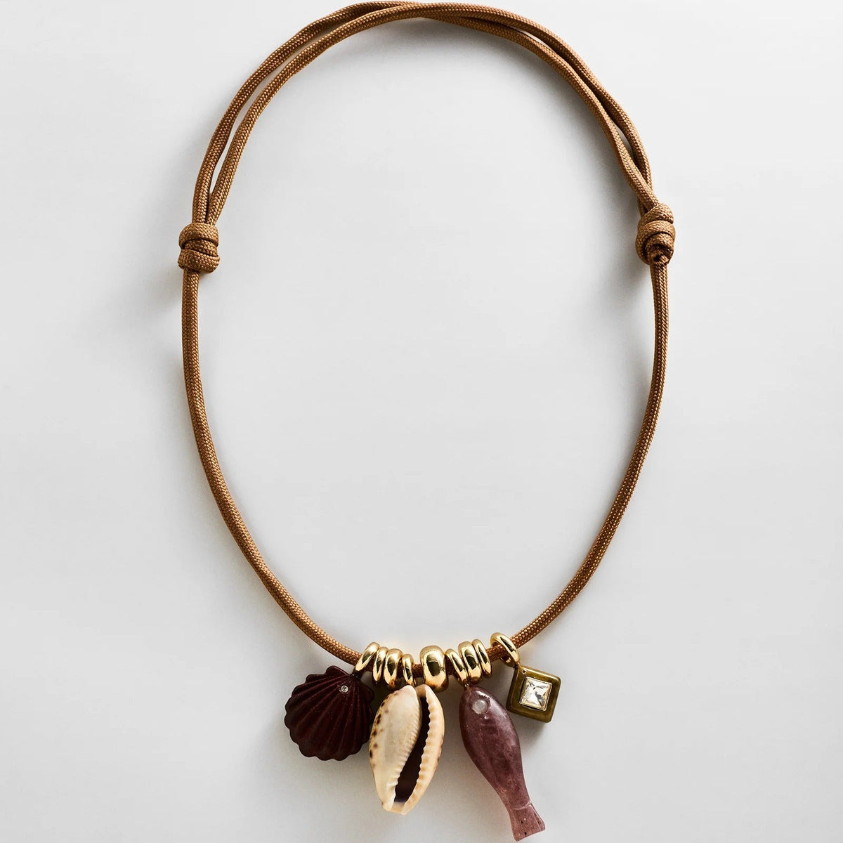 Lavisa Adjustable Cord Charm Necklace with ocean-inspired charms on a thick gold-accented cord.
