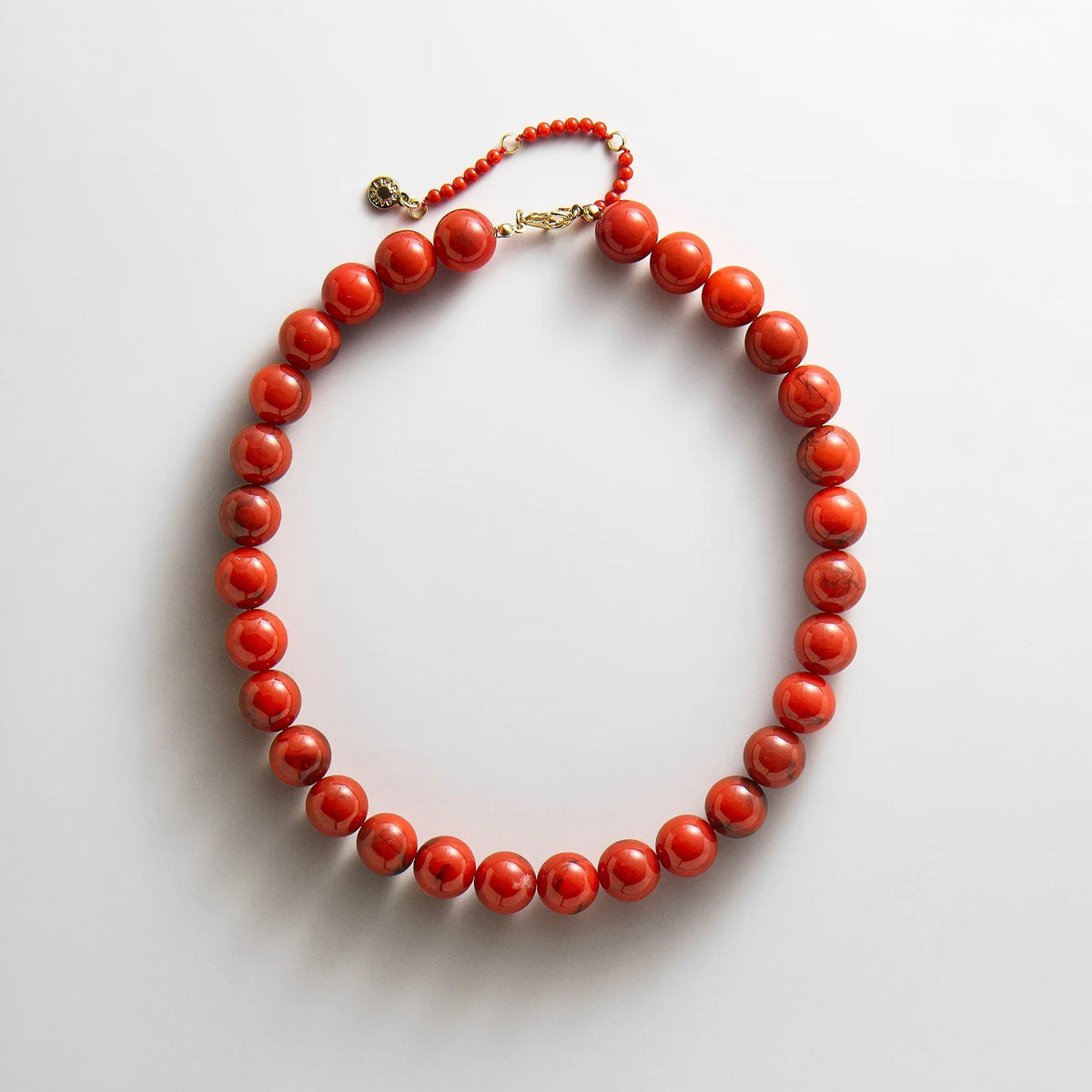 Lavisa cherry red resin beaded necklace displayed on a neutral background