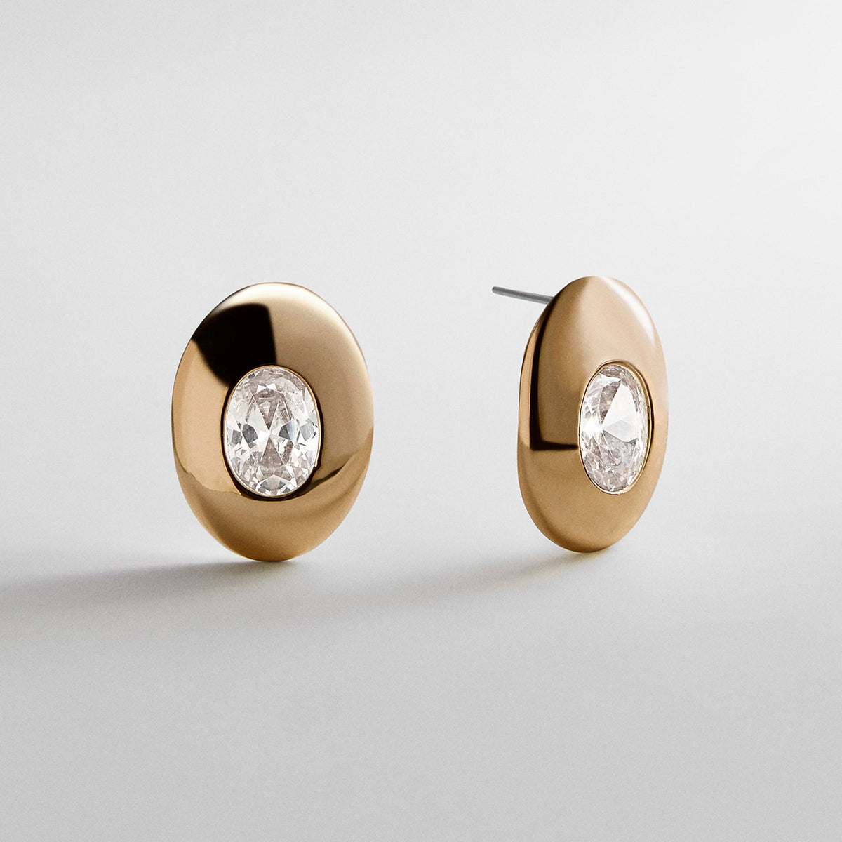 Lavisa gold crystal statement stud earrings on a minimalist display