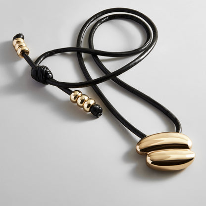 Lavisa asymmetrical gold pendant on an adjustable black cord necklace