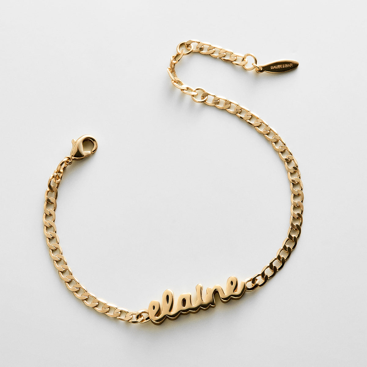 Lavisa custom gold curb chain name bracelet resting on a clean surface