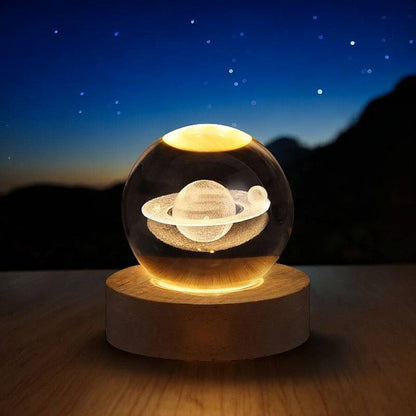 Lavisa 3D Crystal Ball Lamp glowing on a wooden base with a celestial galaxy design - Saturn