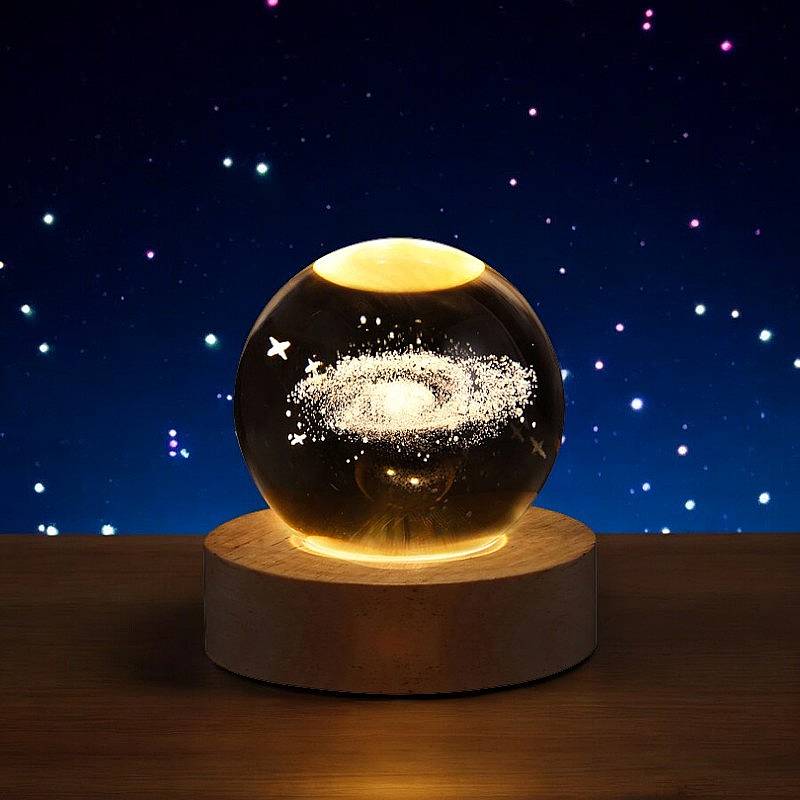 Lavisa 3D Crystal Ball Lamp glowing on a wooden base with a celestial galaxy design - Galaxy