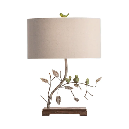 Lavisa nature-inspired table lamp with sculpted birds on a branch and a linen shade
