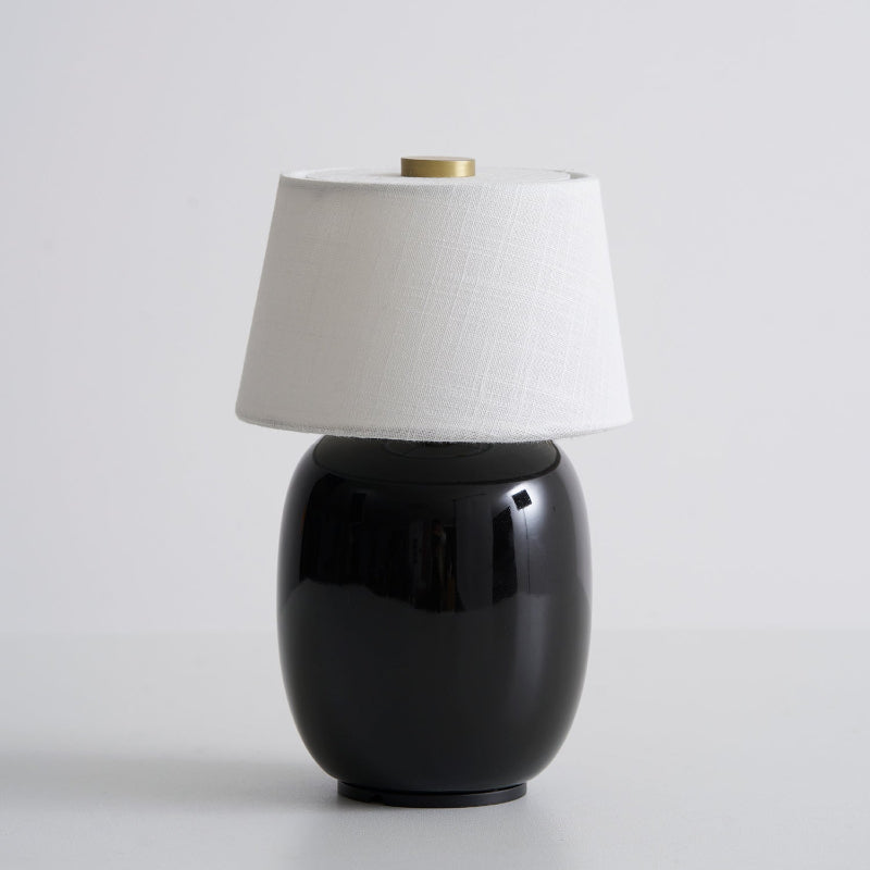 Lavisa Petite Battery Operated Table Lamp glowing on a wooden tabletop - D 4.7″ x H 7.9″ / D 12cm x H 20cm