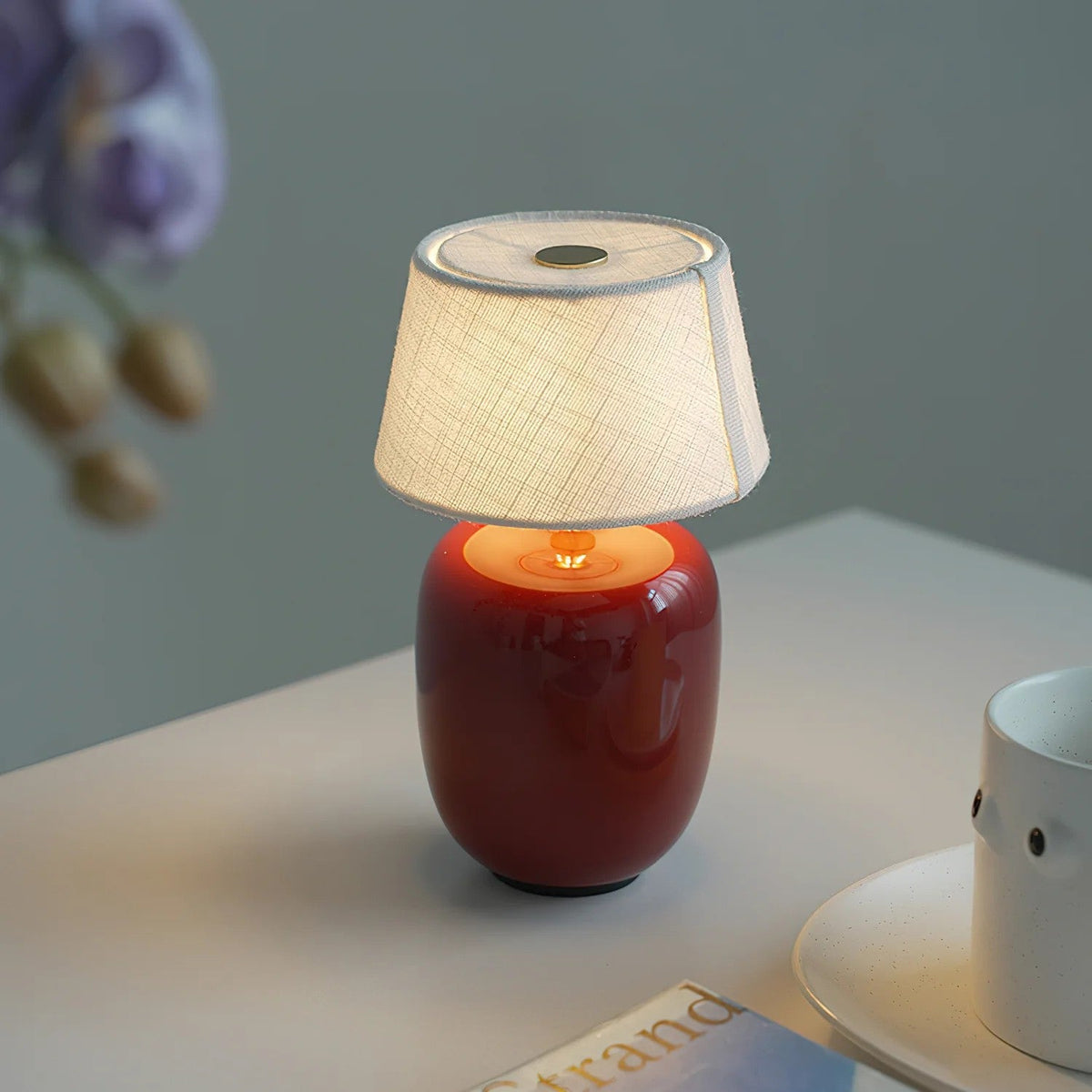 Lavisa Petite Battery Operated Table Lamp glowing on a wooden tabletop